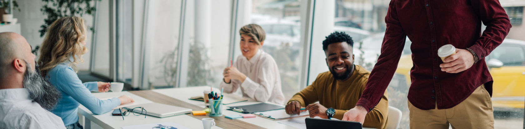 Team of professionals seated around a conference table, engaged in discussion during a meeting.