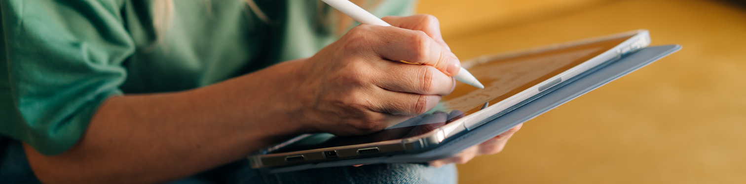 Person using a stylus on a tablet, representing digital readiness and AI adoption planning.